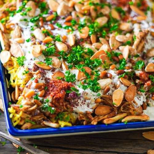 Chicken Fatteh with garlicky yogurt, pita bread, rice, shredded chicken, and garnished with delicious crunchy nuts will make you devour it from the first bite!