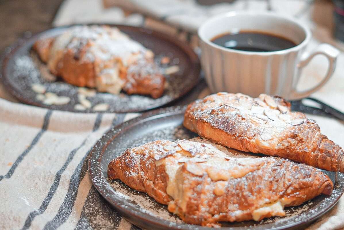 Almond croissants topped with almonds and powdered sugar