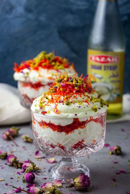 A crust of Knafeh dough soaked in a sweet syrup and layered upon with cream and pistachios served in a cup 