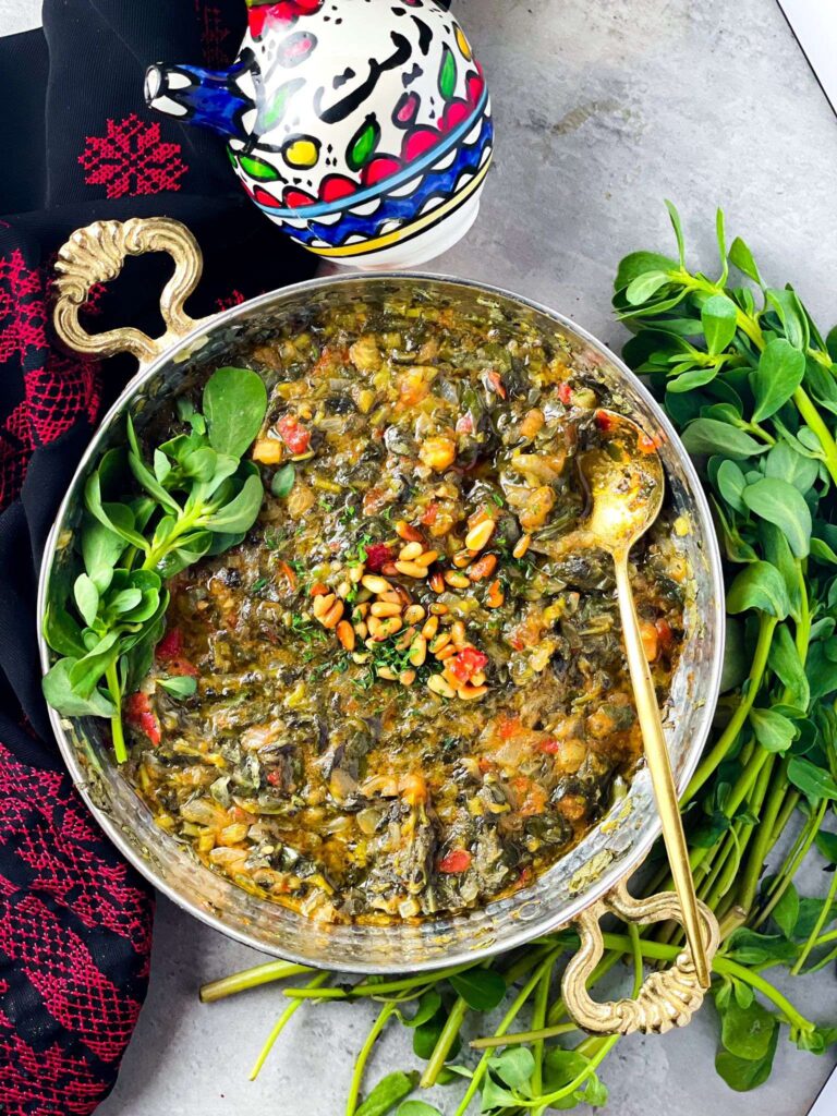 homemade vegetable stew served with olive oil and fresh green leaves of purslane