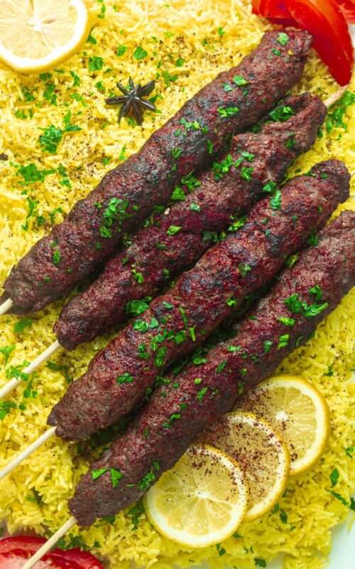Grilled juicy Middle Eastern Kebabs on a skewer served with rice and a sprinkle of parsley that leaves a mesmerizing sensation in your taste buds.