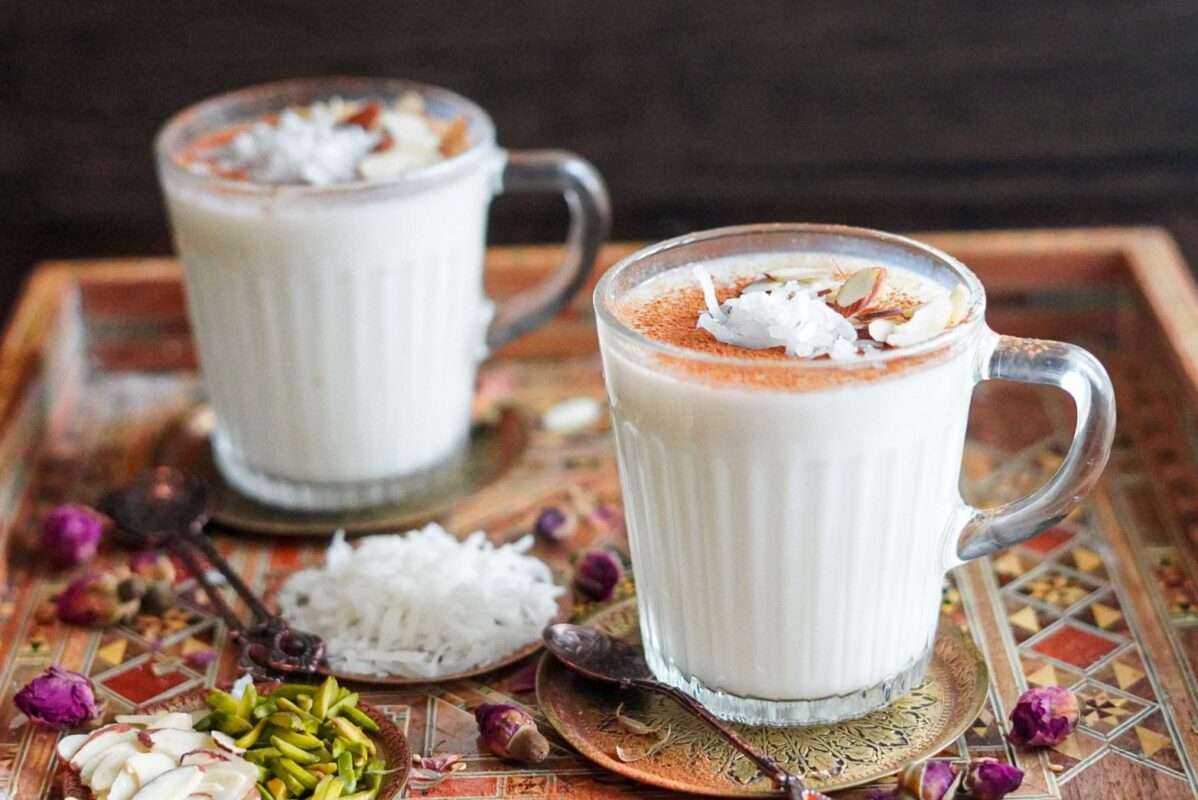 homemade cozy sahlab drink topped with ground cinnamon, almonds, and shredded coconut