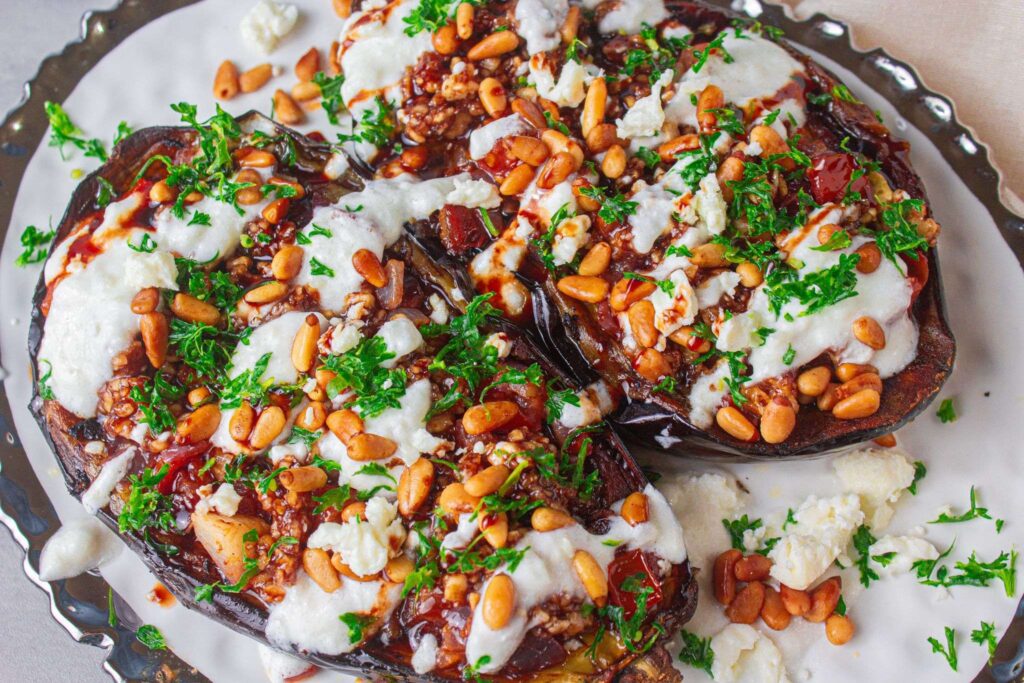 Vegetarian Loaded Eggplant topped with tomato and onion mixture, pomegranate molasses filling and yogurt