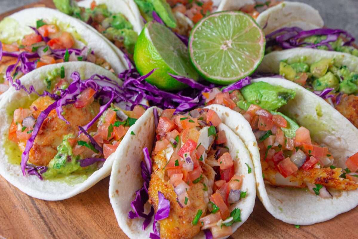 These Fish tacos are seasoned and pan-seared. They are coated with veggies and a tangy, lemony sauce.
