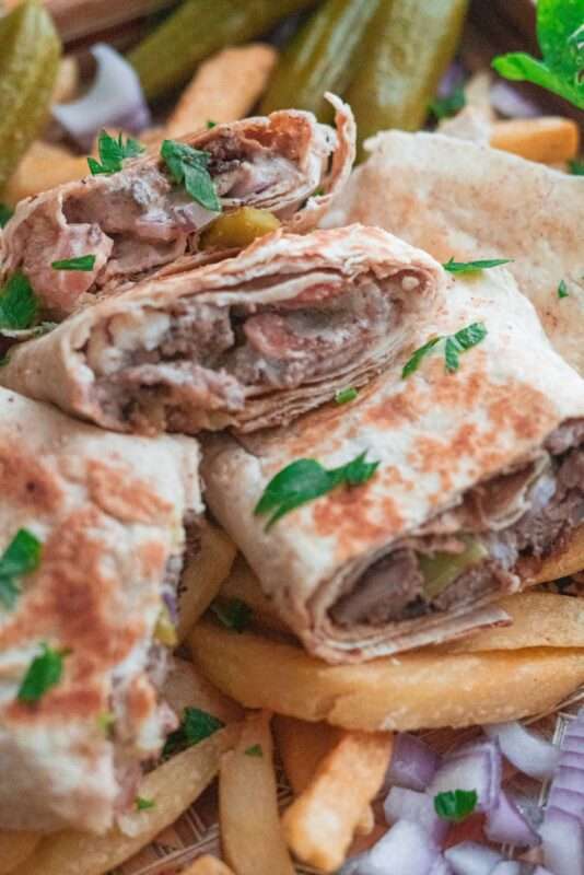 A beef shawarma wrap served with French fries, pickles and sumac onions. 