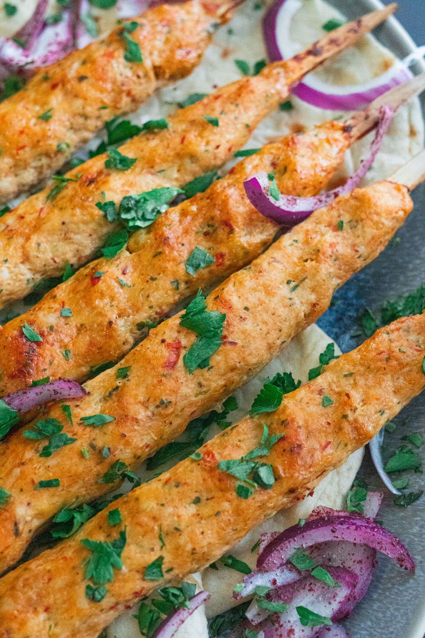juicy and tender chicken kofta kebabs served with sumac onion salad and finely chopped parsley