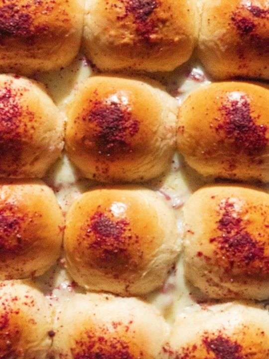 These are some sliders roasted in the oven. The sliders are stuffed with chicken musakhan and mozzarella and drizzled with sumac powder.