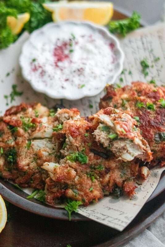 Soft fritters garnished with vibrant green parsley and served yogurt