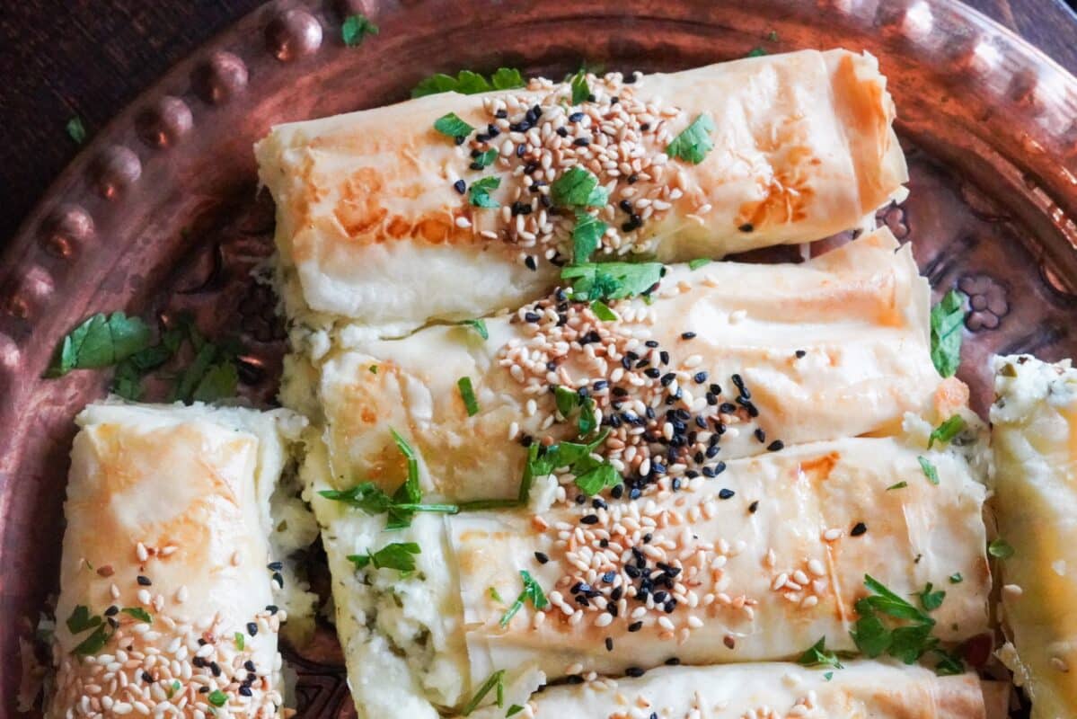Grilled golden Turkish borek topped with sesame seeds, and filled with delicious cheese and parsley. 