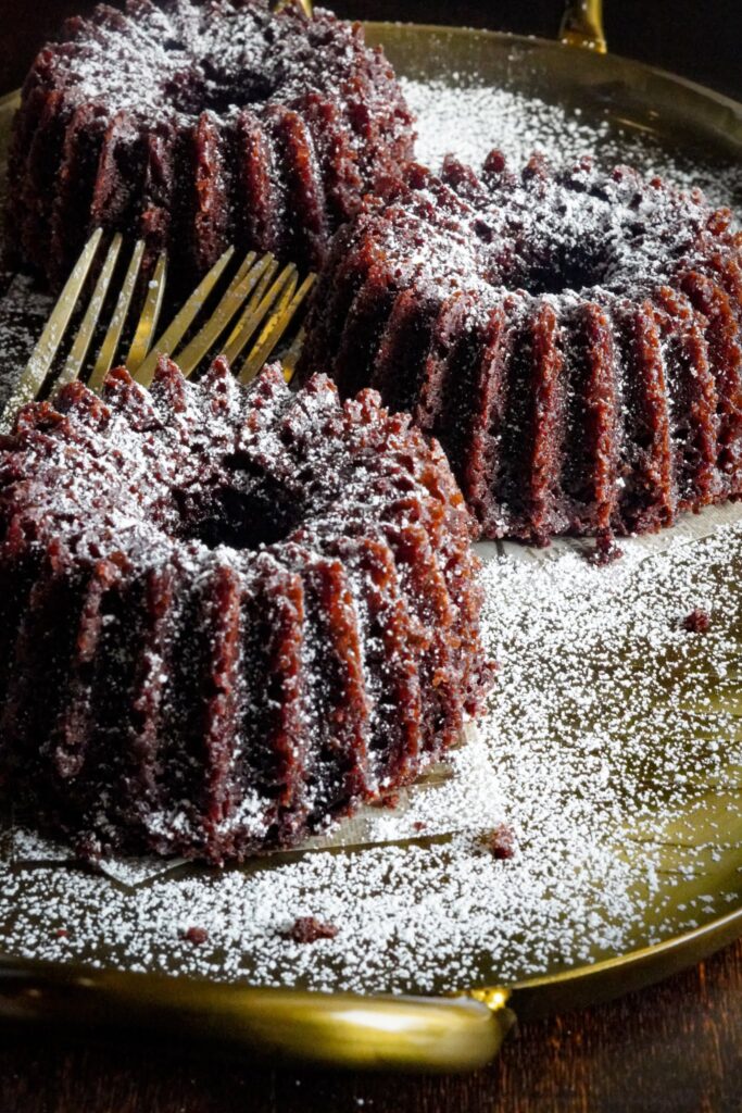 Three pieces of eggless chocolate cake dusted with powdered sugar.