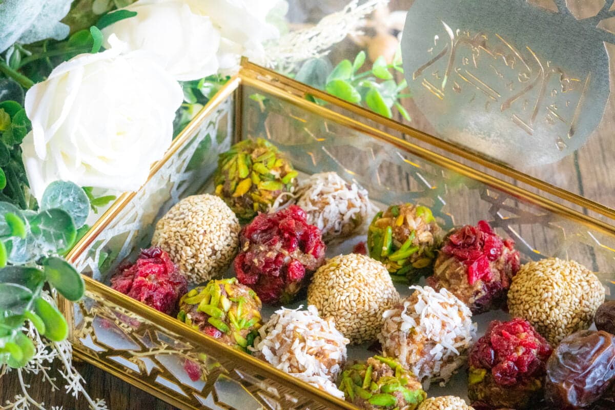 A box of energy date balls with different flavors from pistachios to sesame seeds, and cranberries.