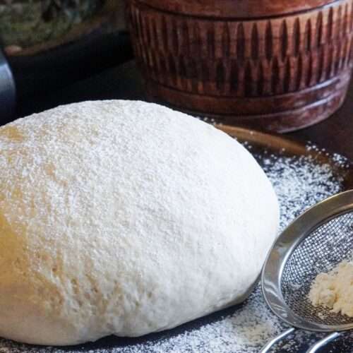 A ball of dough surrounded by flour.