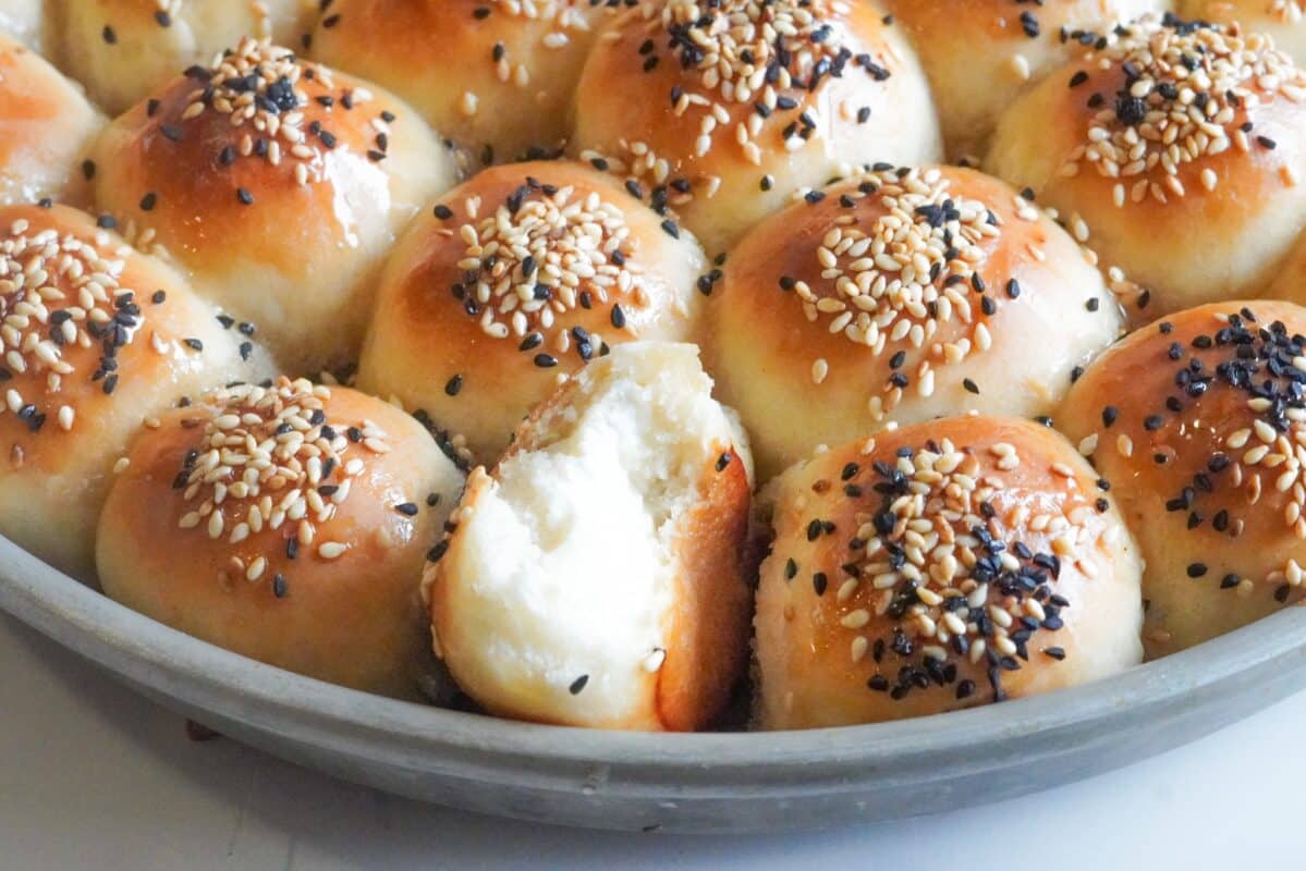 soft and fluffy honeycomb bread stuffed with cream cheese topped with sesame and Nigella seeds, and drizzled with honey 