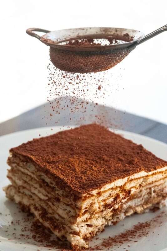 In this icebox cake, biscuits, heavy cream, and instant coffee are layered with cocoa powder for an irresistible taste. 