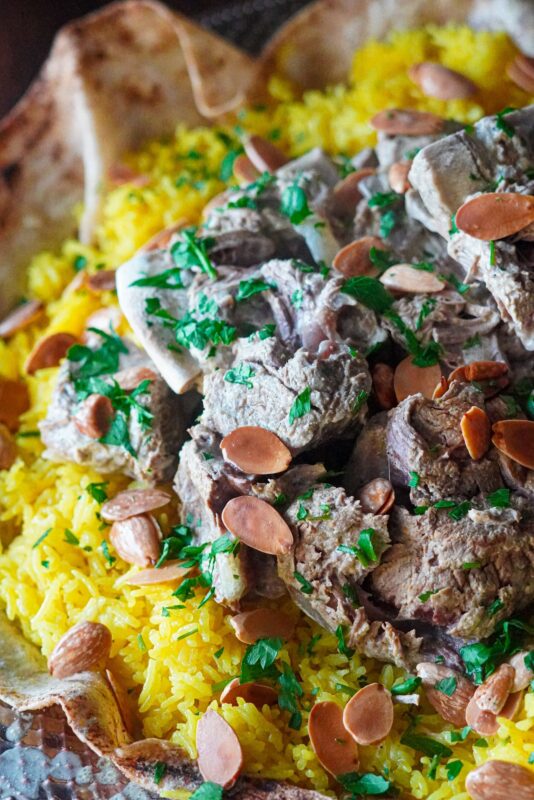 A dish of yummy mansaf that consists of fluffy rice, tender lamb and topped with nuts. 