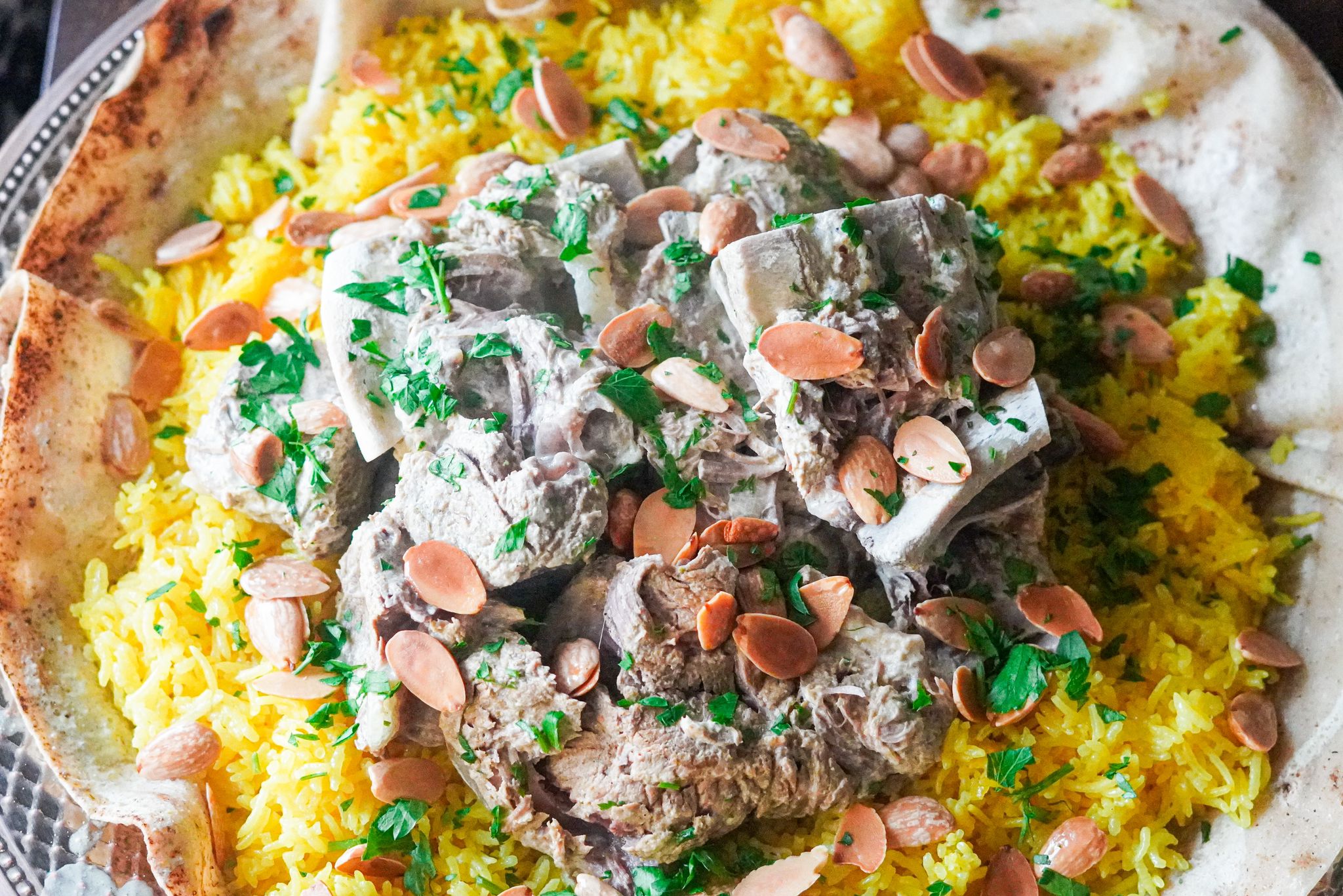 Mediterranean Mansaf is a traditional dish composed of layers of bread, rice, and tender chunks of lamb served with a special yogurt sauce
