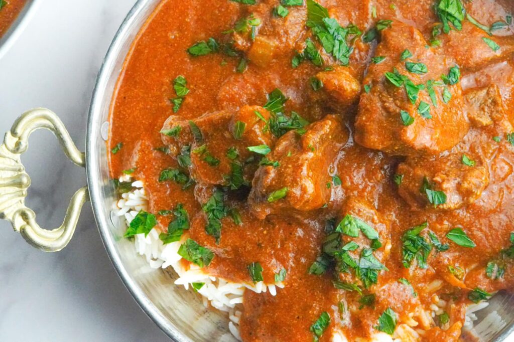 Vibrant beef curry stew served on top of white rice