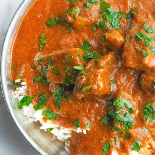 Vibrant beef curry stew served on top of white rice