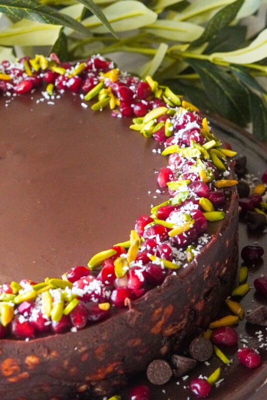 a special soft and creamy lazy cake with chocolate chips and decorated with pomegranate seeds, shredded pistachios, and coconut shreds