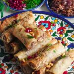 Classic Palestinian Msakhan roll-ups are stuffed with delectable chicken, puckering sour sumac, sweet caramelized onions, delicious olive oil, and balanced out with the warmth of aromatic spices