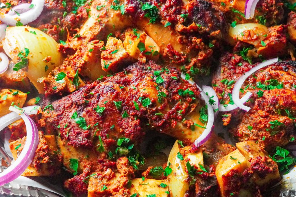 delicious golden baked marinated chicken thighs sparkled with chopped parsley and slices of red onions