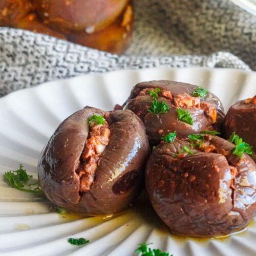 Traditional stuffed makdous recipe served on a white plate garnished with chopped herbs