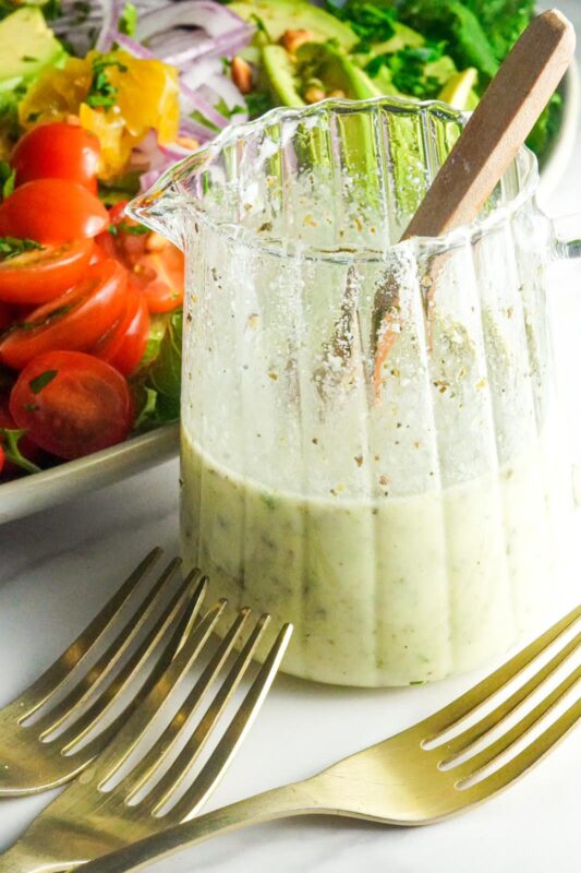 A container with creamy salad dressing for Middle Eastern style chicken salad.
