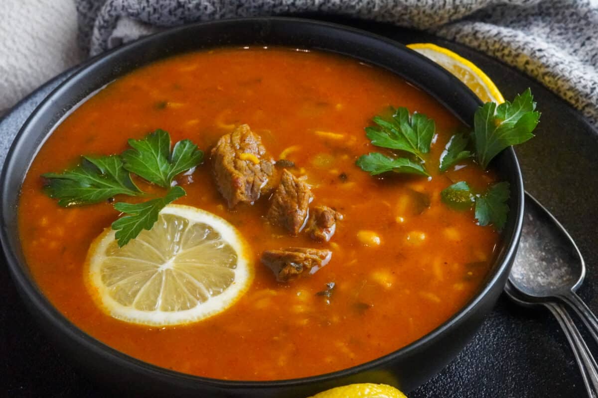 Moroccan Harira soup with lamb served with lemon wedges and fresh parsley