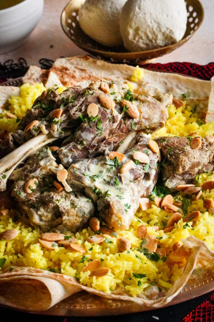 Mansaf is a delicious Jordanian dish with distinct flavors that includes bread, rice, meat, and a rich and tangy yogurt sauce. 