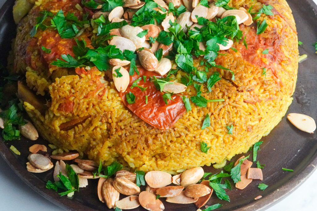 vegan Makloubeh, featuring eggplant, cauliflower, potatoes, onion, and rice, and served in a captivating upside-down style