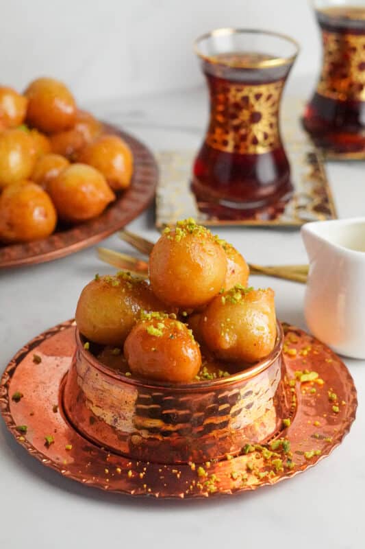 Luqaimat are deep-fried round doughnuts with a crunchy texture and golden-brown color on the surface while staying light and airy on the inside.