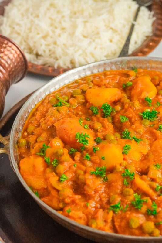 Vegetarian curry, aloo matar served with a bowl of white rice
