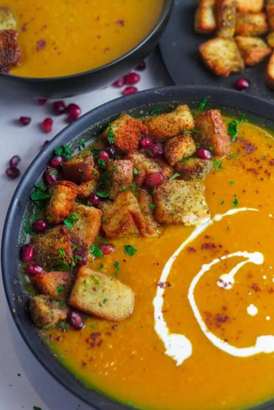 Butternut Squash Soup served with za'atar croutons, garnished with chopped parsley and pomegranate seeds