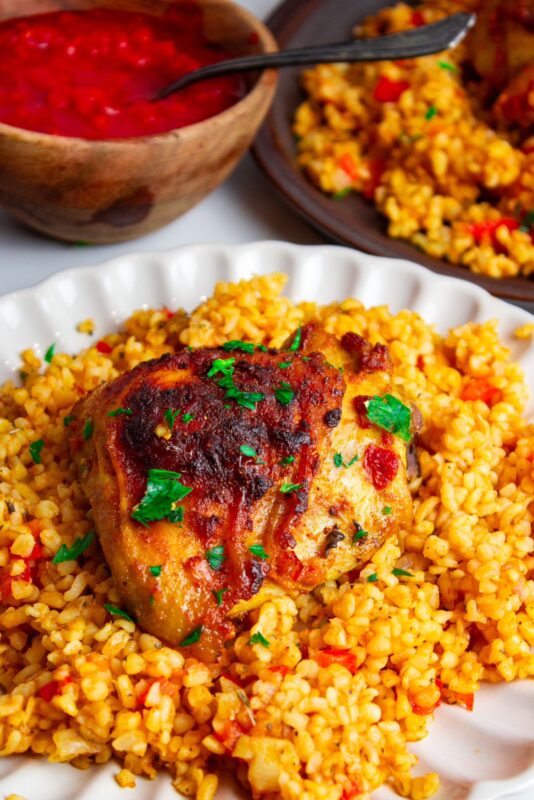 baked Harissa garlic chicken served on top of Turkish bulgur pilaf dish and garnished with finely chopped fresh parsley