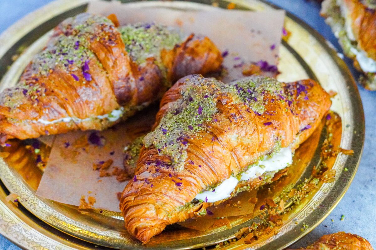 Two pistachio and ashta filled croissant garnished with ground pistachios