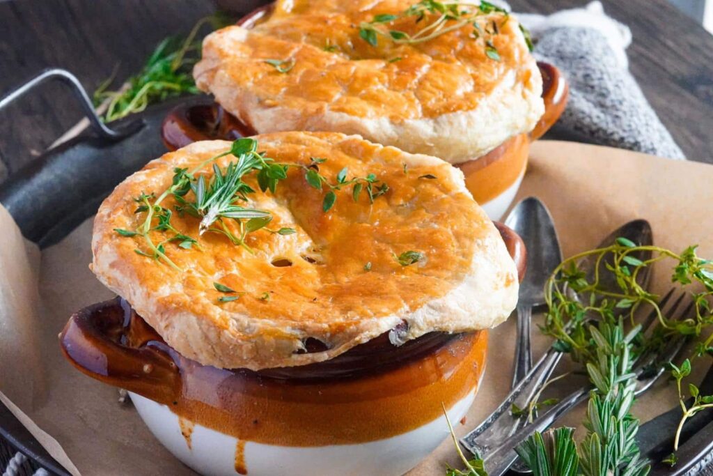 two pots of chicken pie served warm with fresh rosemary on top