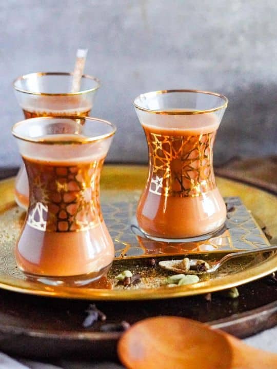 Yemeni Adeni tea fills glasses on a bronze tray.