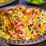 A dish of Persian jeweled rice with toppings like carrots, pistachios, and almonds