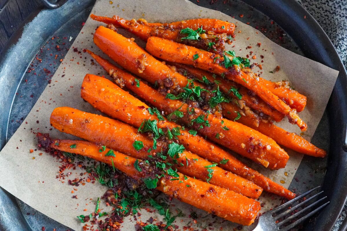 A pan of roasted carrots seasoned with olive oil, garlic, onion powder, and other seasonings
