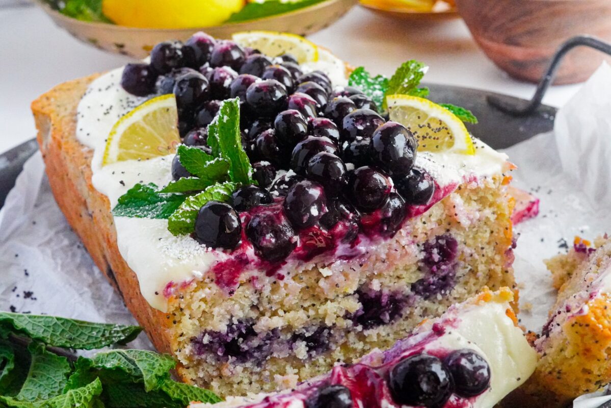 a lemon and blueberries cake with poppy seeds, syrup, and fresh blueberries