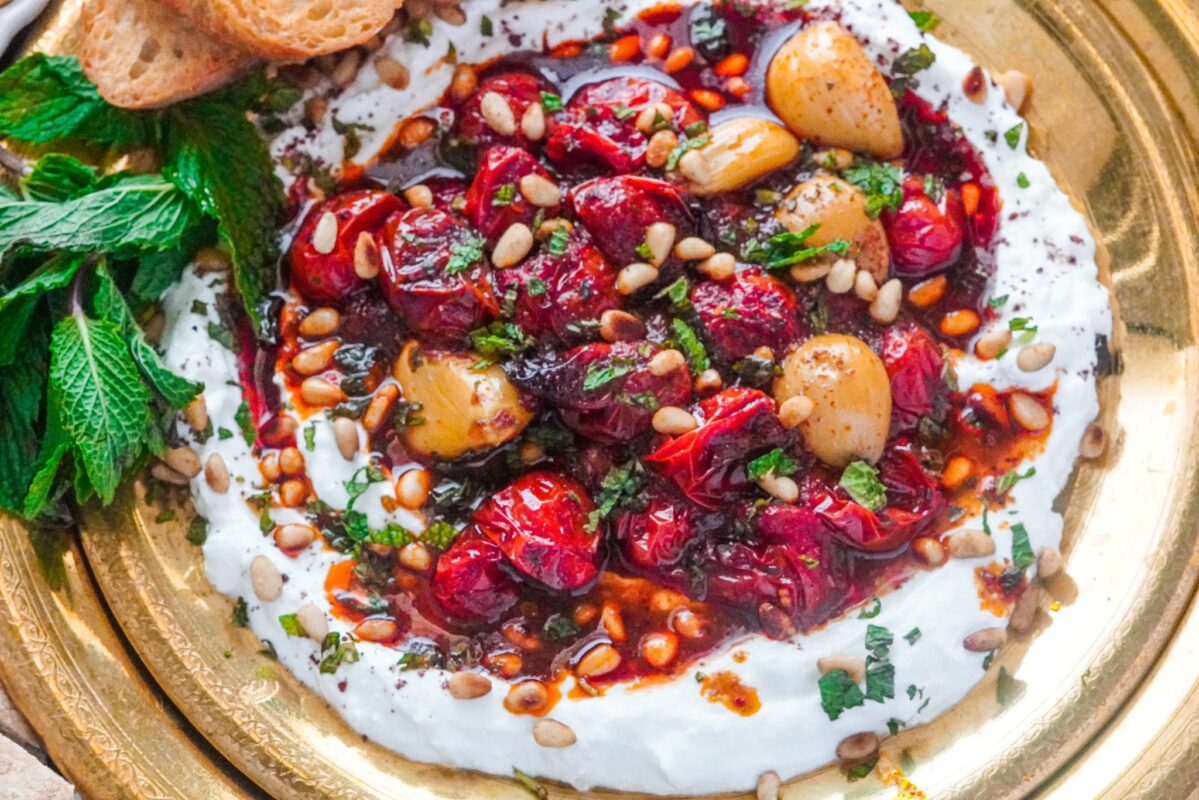 a dish of spiced cherry tomatoes on labneh