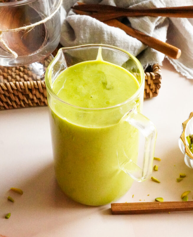 A tall glass filled to the brim with green pistachio spread.