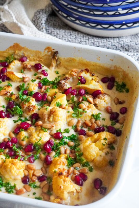 This Vegan Cauliflower Tahini Bake topped with parsley, fried nuts, and pomegranate will uplift your table on all occasions.  