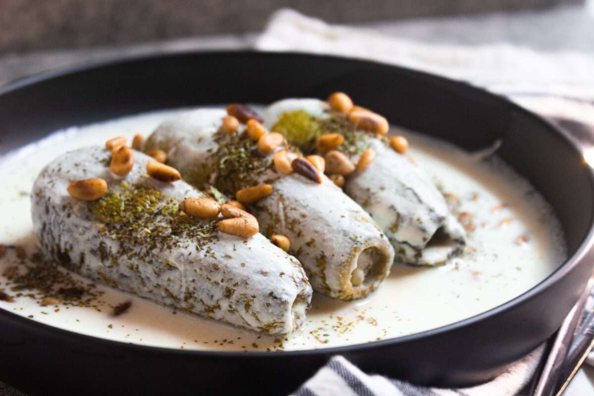 Sheikh Makhshi (Kusa Bi Laban) exquisite Palestinian main dish with zucchinis filled with meat and submerge in a garlic yogurt sauce. Sprinkled with nuts!