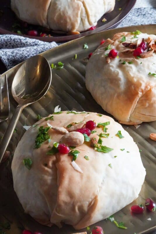 Scrumptious Pockets Flavor Unforgettable beef ouzi pockets flavor decorated with toasted nuts, finely chopped fresh parsley, and fresh pomegranate seeds
