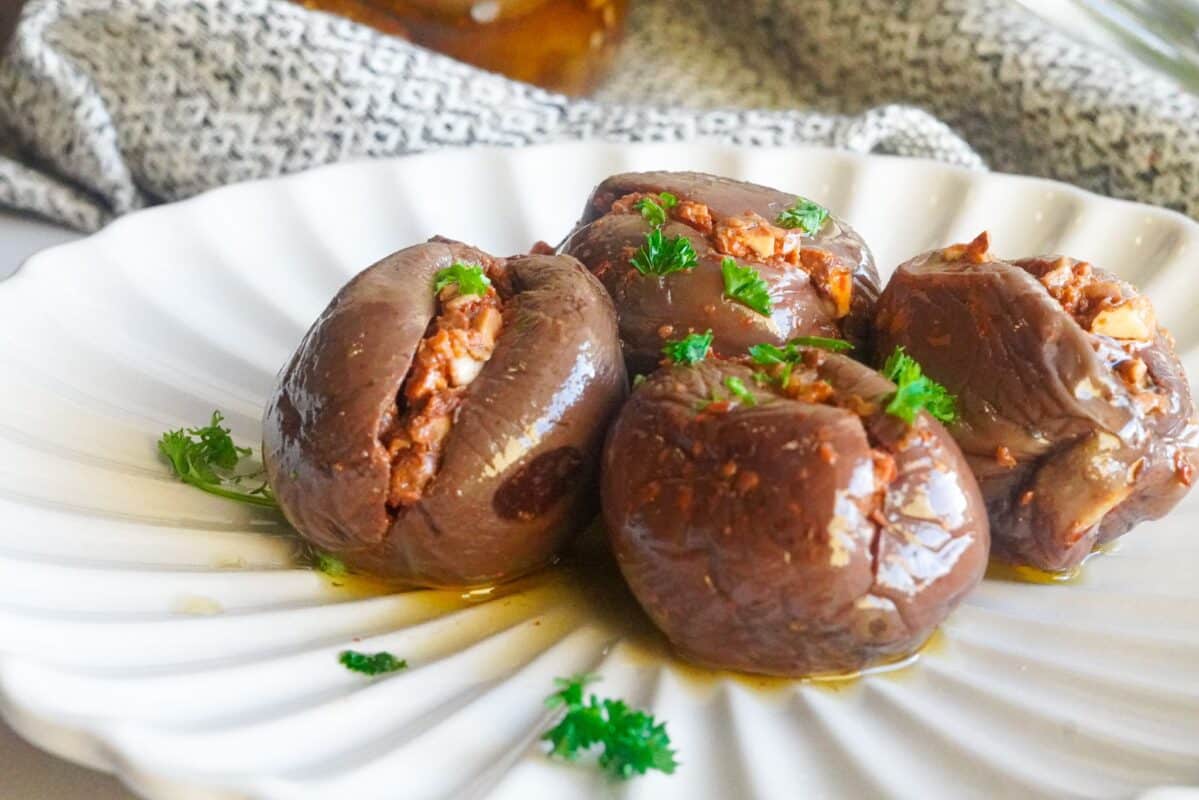 a plate of middle eastern stuffed makdous sprinkled with finely chopped parsley.