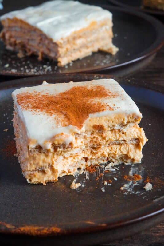 A captivating close-up of a dessert piece made of graham crackers, pumpkin puree, pumpkin spice, and dusted with cinnamon