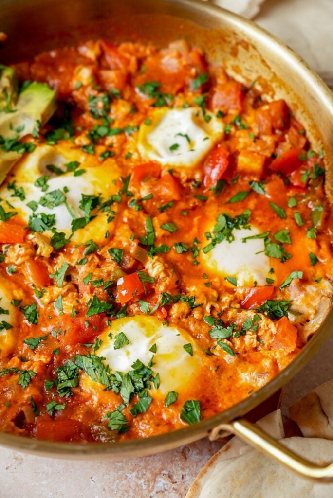 A pan of freshly made shakshuka garnished with fresh parsley