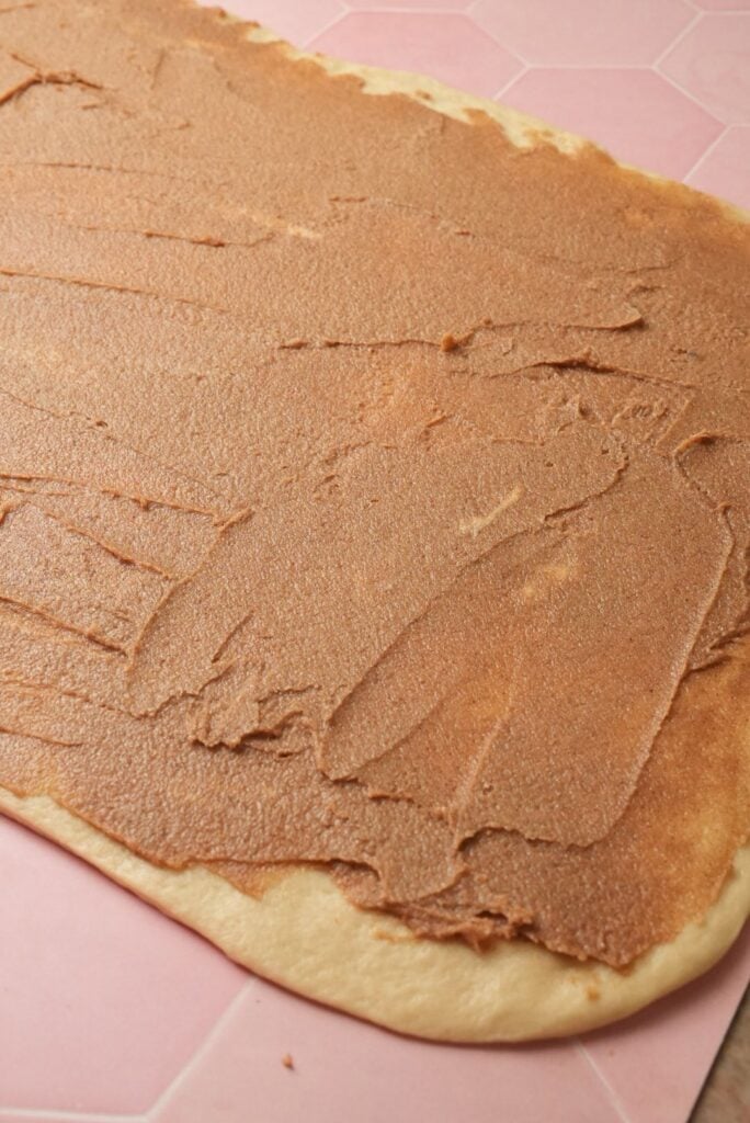 a shot of evenly spreading the cinnamon sugar filling over the dough