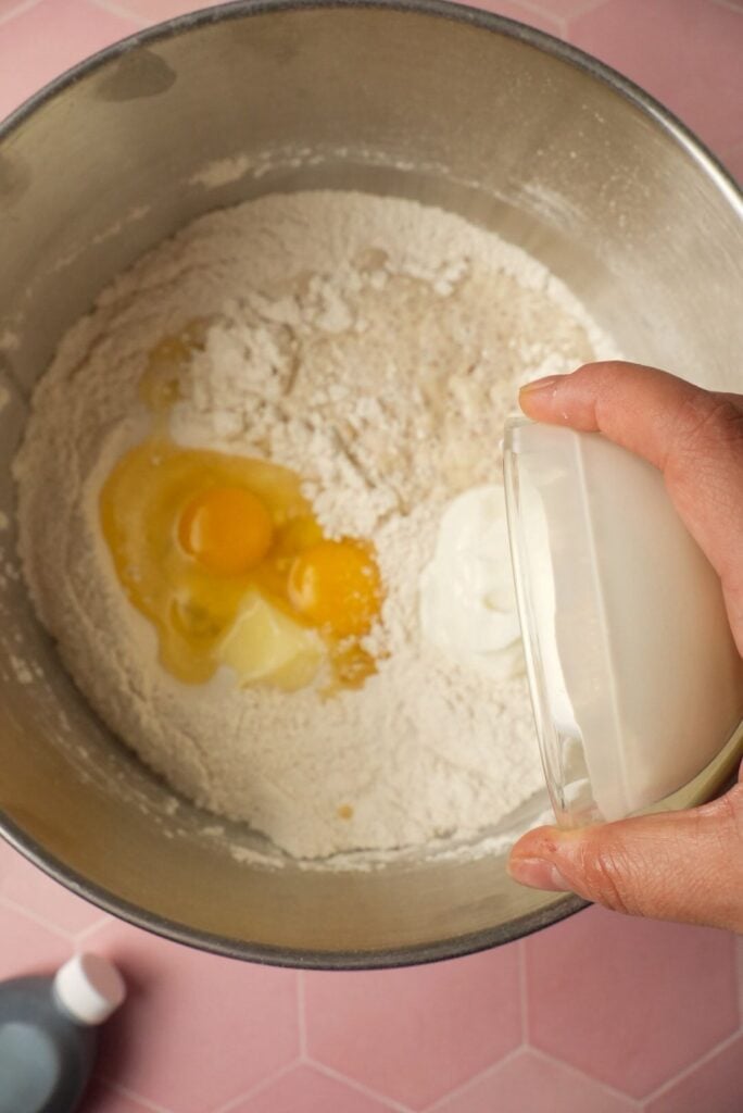 adding the activated yeast mixture to the dough ingredients like eggs, flour, etc.